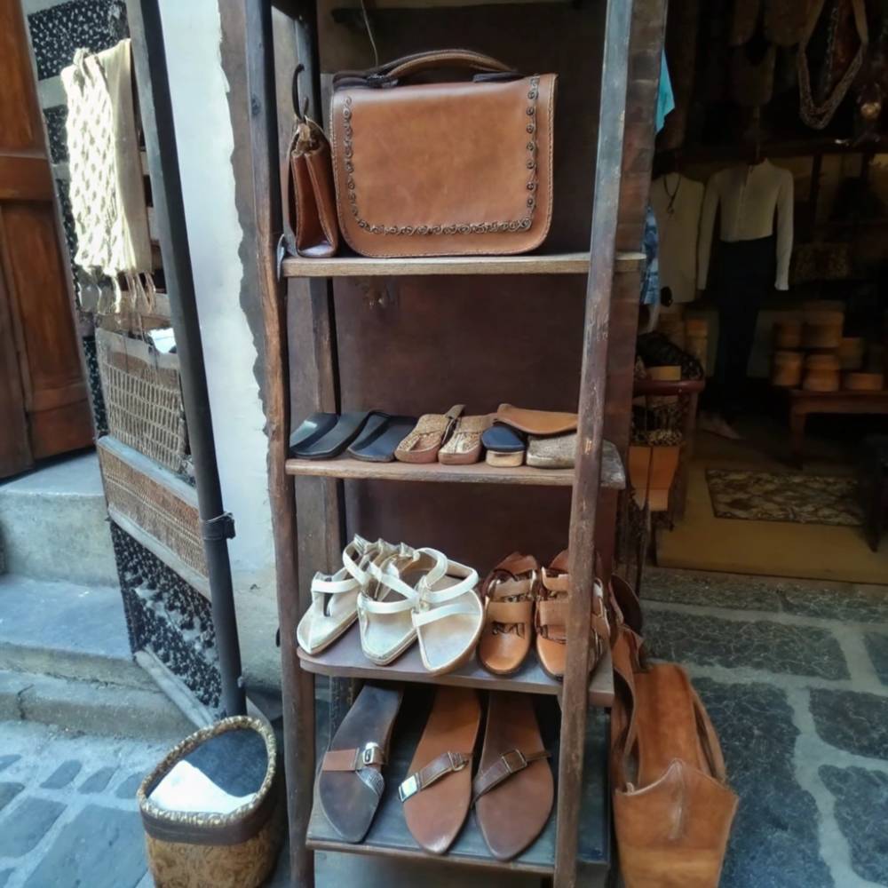 Display of handmade leather sandals and a bag in a traditional Rhodes shop, showcasing the skill and style of Greek leather craftsmanship. Located in the charming Old Town, this display highlights the use of natural materials and classic designs.